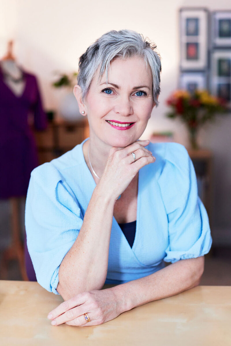 Portrait of Lucy,  a styling coach, arranging  a neckless on a mannequin