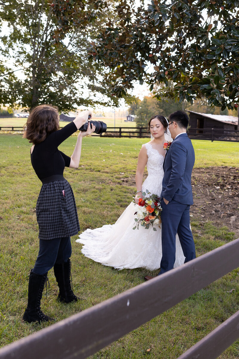 Top wedding photographer in raleigh nc in black and grey dress taking photo of bride and groom at oxford venue