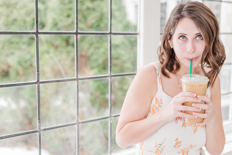 woman looking away from the camera while sipping on iced ocffe