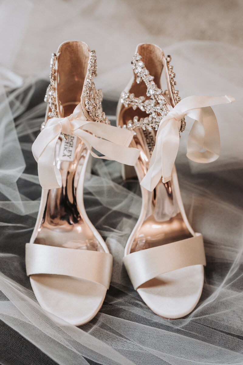 Close up of the brides shoes on top of her veil on her wedding day