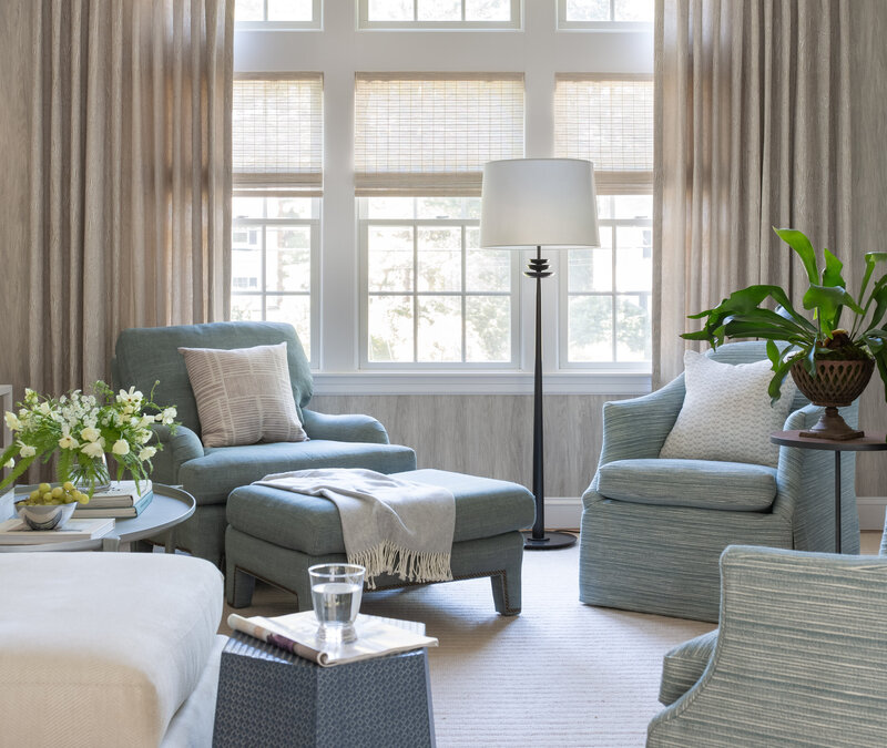Hingham interior designer create coastal blue family room featuring light blue lounge chairs, a leather side table, and neutral decor with a refined coastal aesthetic.