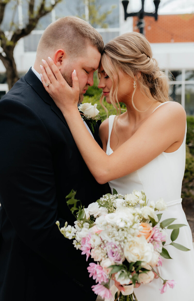 Candid wedding photo capturing a tender moment between bride and groom, taken by West Michigan wedding photographer for modern couples.