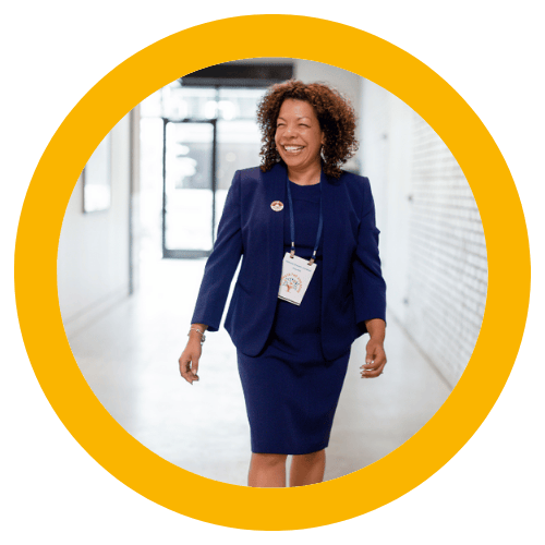 Photo of Michelle McKown-Campbell smiling while walking down a hall