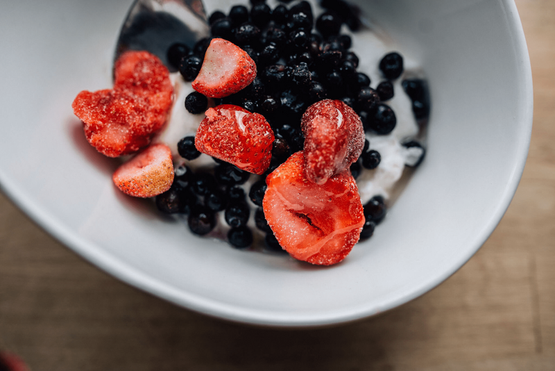 white bowl filled with strawberries, blackberries and yogurt