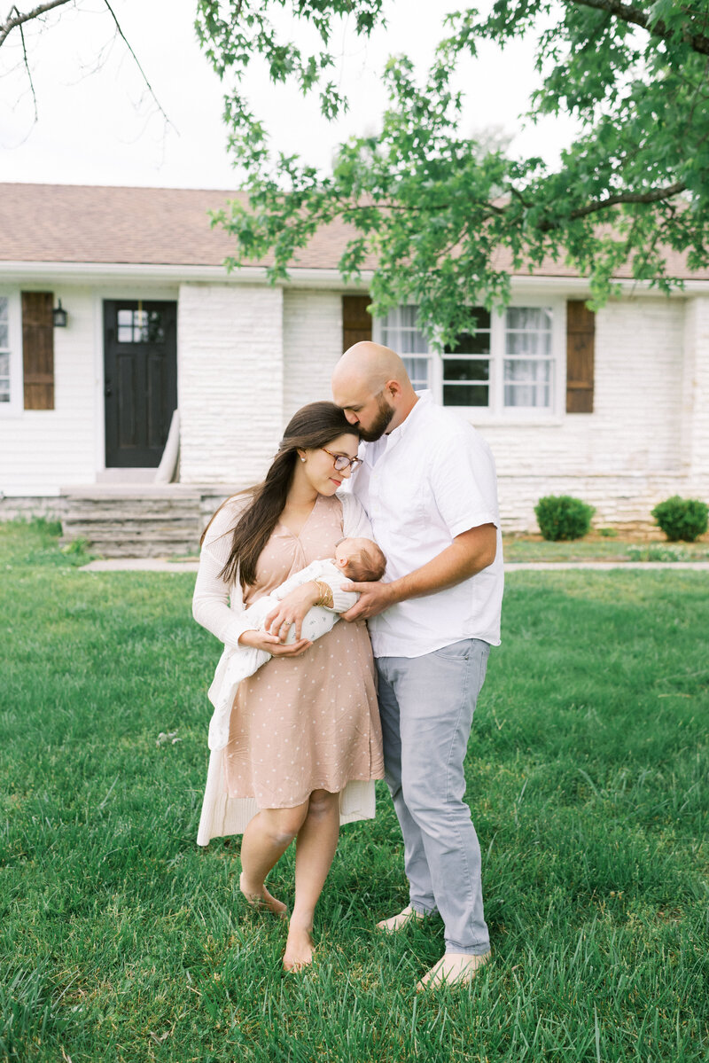 Outdoor photo of couple with newborn baby