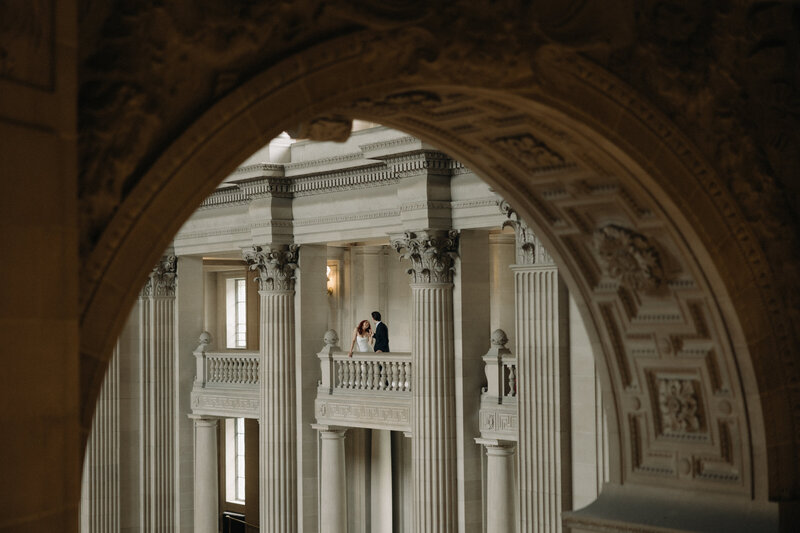 Intimate elopement at San Francisco City Hall, captured in a documentary-style photograph with a mix of digital and film, showcasing candid moments and the architectural beauty of the iconic venue.