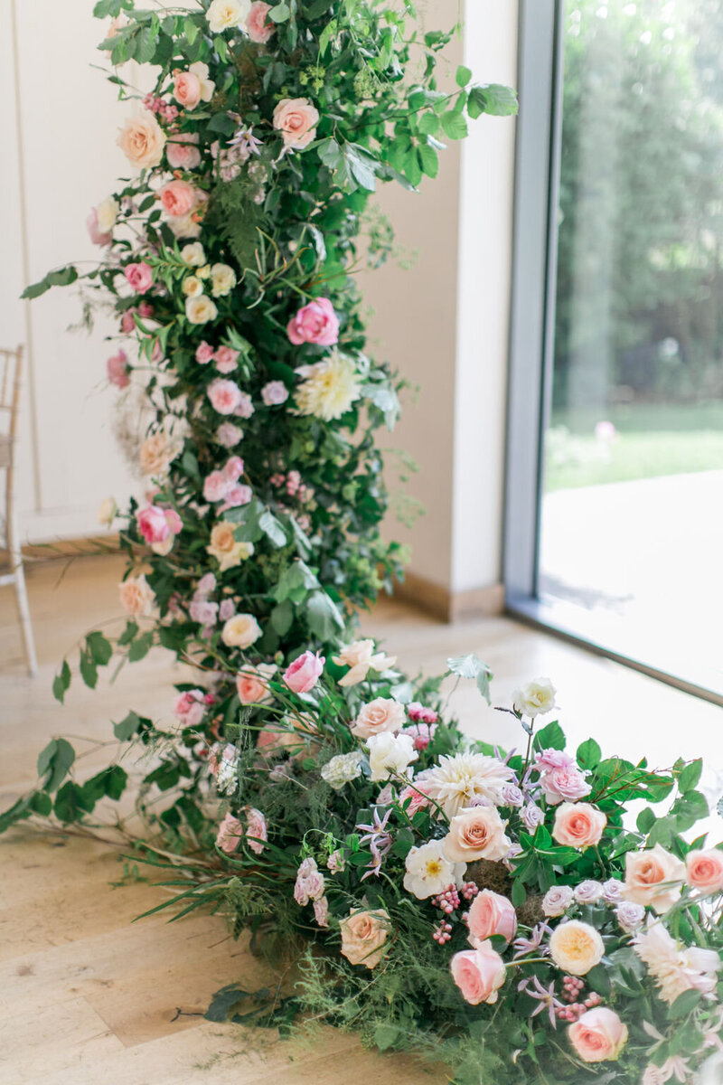 A floral hoop display at the front of a wedding ceremony at Millbridge Court