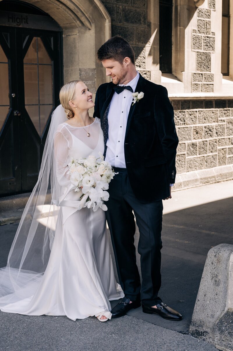 a newly married couple in the arts centre in christchurch with qhite ivory bouquet by the flower press nz