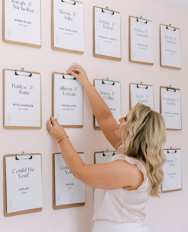 Elizabeth hanging a clipboard with client wedding plans