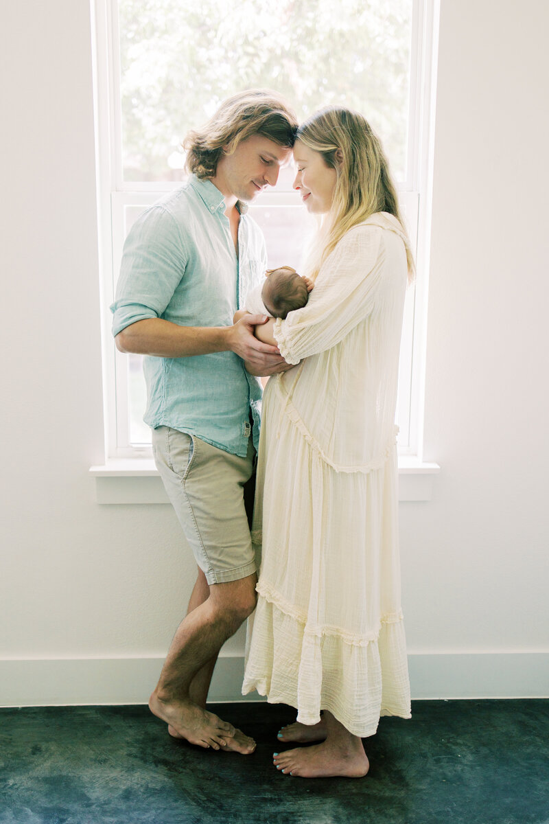 Austin newborn parents smile at each during their newborn session.