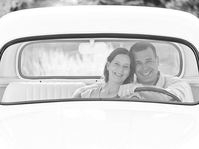 Couple smiling and sitting close together in a white truck outdoors in North East, PA.