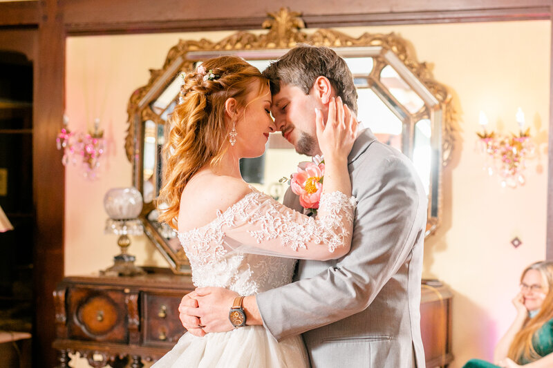 A bride and her groom share a sweet moment during their first dance in the ballroom with Gramercy Mansion Wedding Photographer