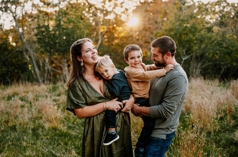 Family laughing and playing at sunset in Massachusetts