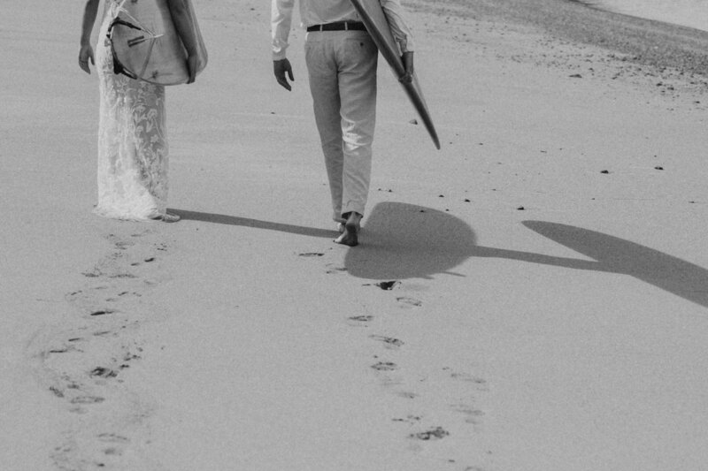 black and white image couple walking on beach
