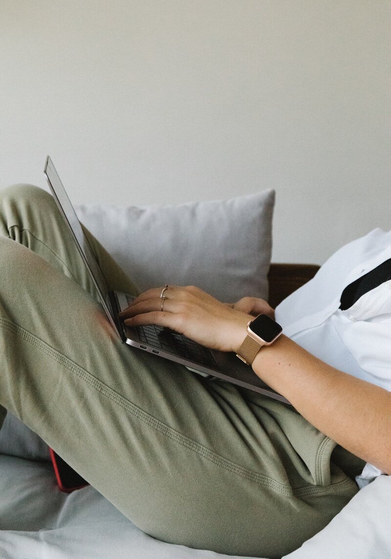 Woman browsing on her laptop while sitting on couch