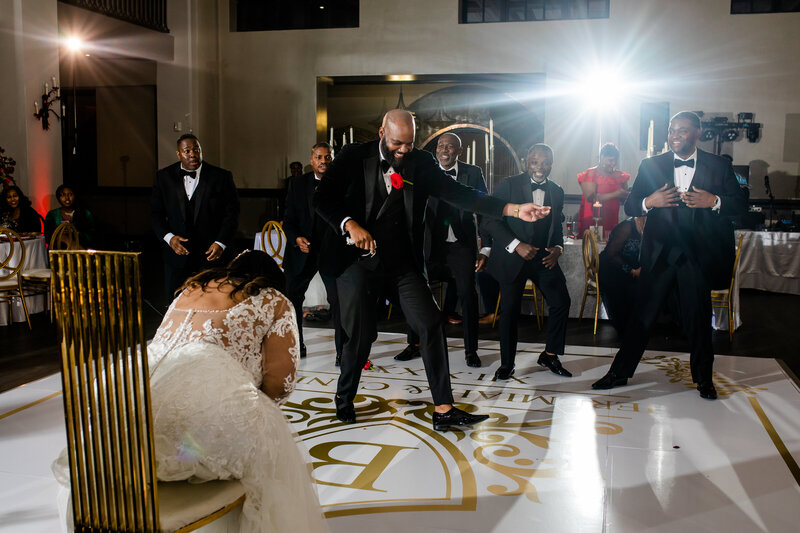 Captured after their wedding at The Cotton Press, this fashionable Black couple poses in the marble inset at the SC Statehouse, with the bride's veil flowing gracefully. A picture of style and luxury.