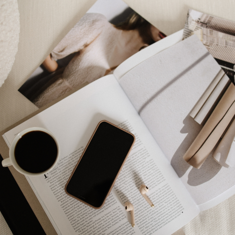 Elegant flat lay with smartphone, earbuds, coffee, and open magazine—perfect for representing digital design, branding, and creative workspaces