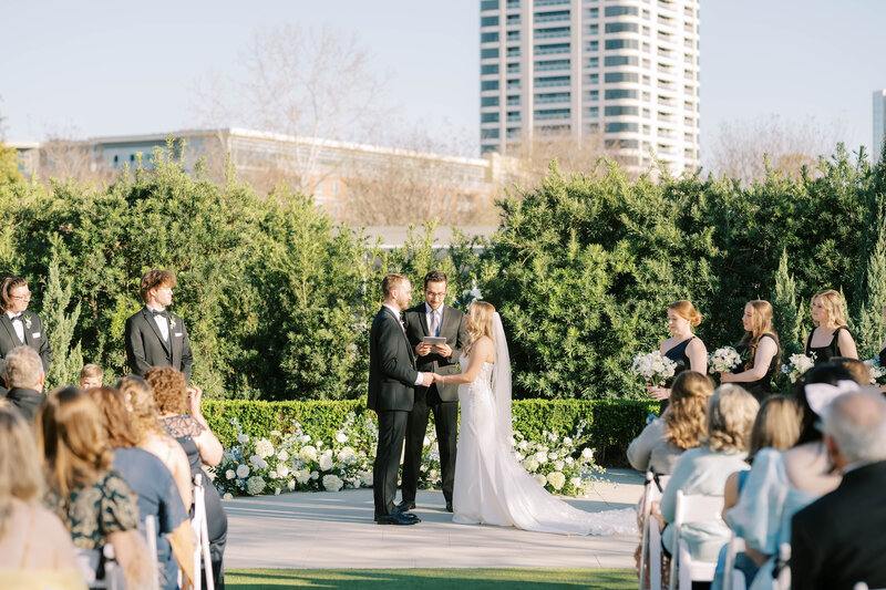 Bride and groom kissing while bridal party cheers around them