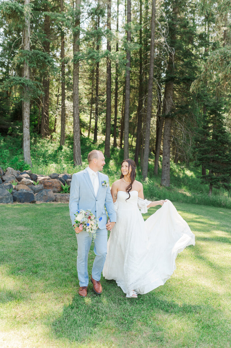 bride and groom walking in green open field at twin creeks farm wedding venue