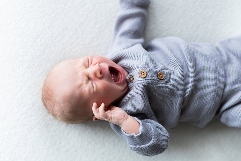 newborn baby boy having a wide yawn