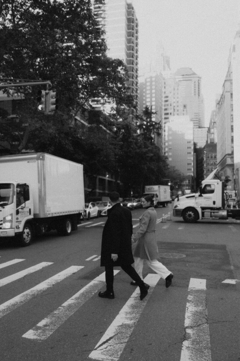 Man and woamn holding hands crossing a busy NYC street in the fall in New York City, NY, documented by Andrea-Marie Photography