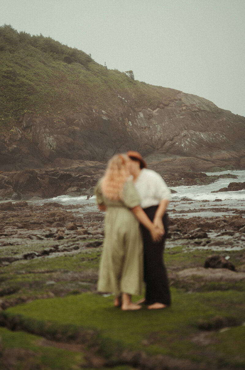 couple kissing by the coast