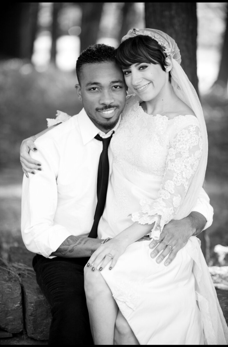 bride sitting in grooms lap wedding portrait