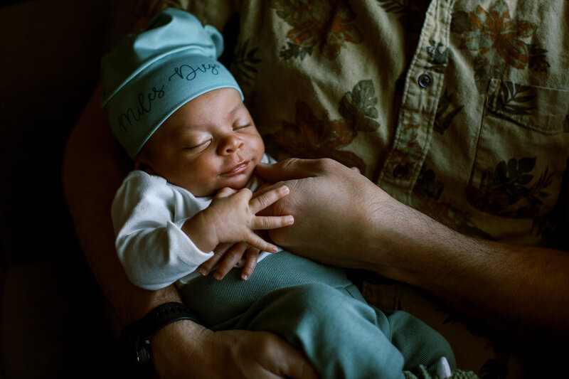 cute baby sleeps in dad's arm