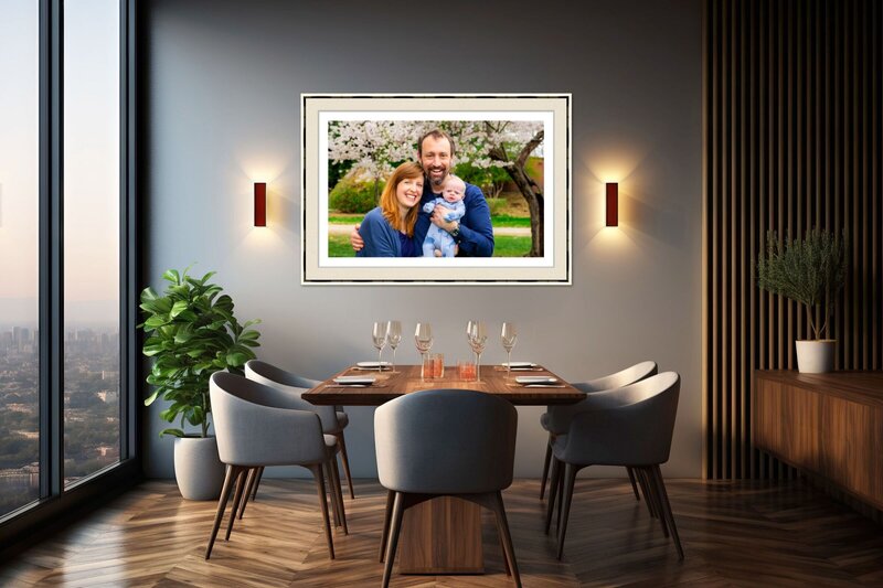 Framed family portrait of parents with their baby displayed on a dining room wall, captured and designed by Capture Joy Photography, Northern Virginia family photographer.
