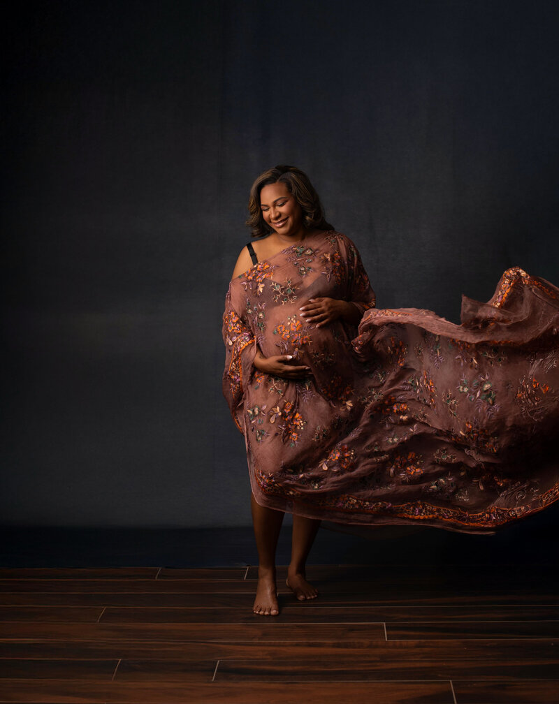 Expecting Mom Posed in Kaftan on a backdrop with everything analogous colors