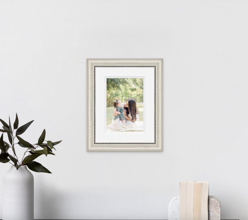 mockup picture of a wall portrait showing a mother in a white dress and her baby daughter, beautifully captured by an Austin Family Photographer.