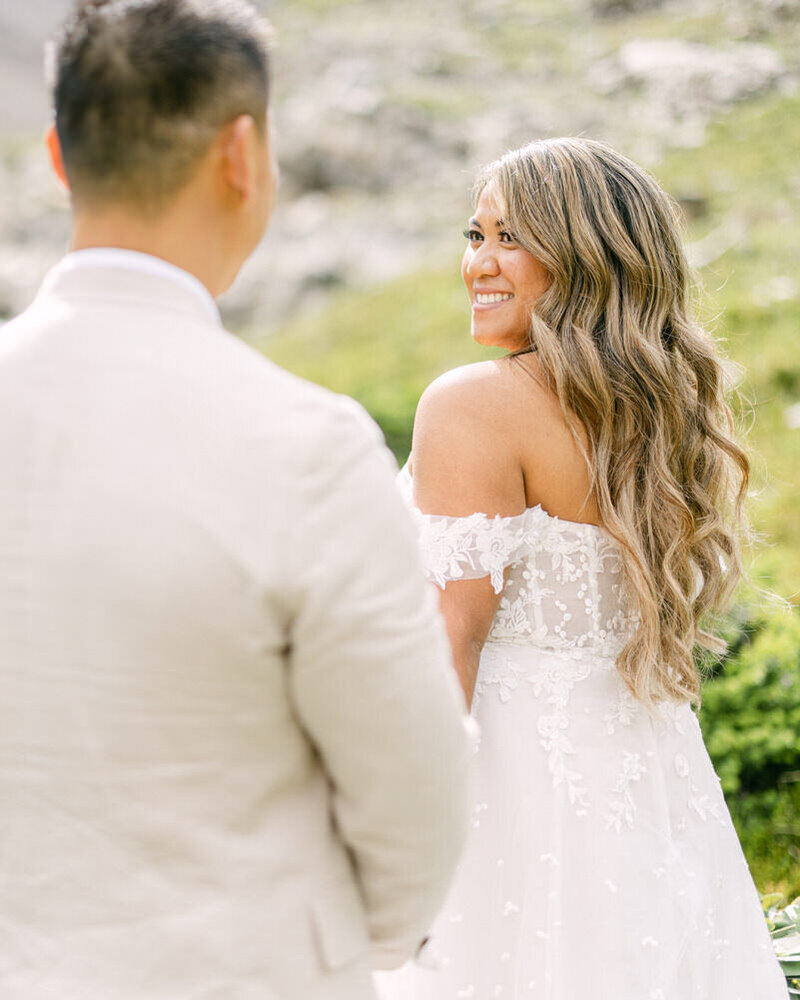 A stunning portrait of a bride glancing back at her groom during their session at the Cornerstone Canmore Theatre, capturing a timeless and romantic moment.