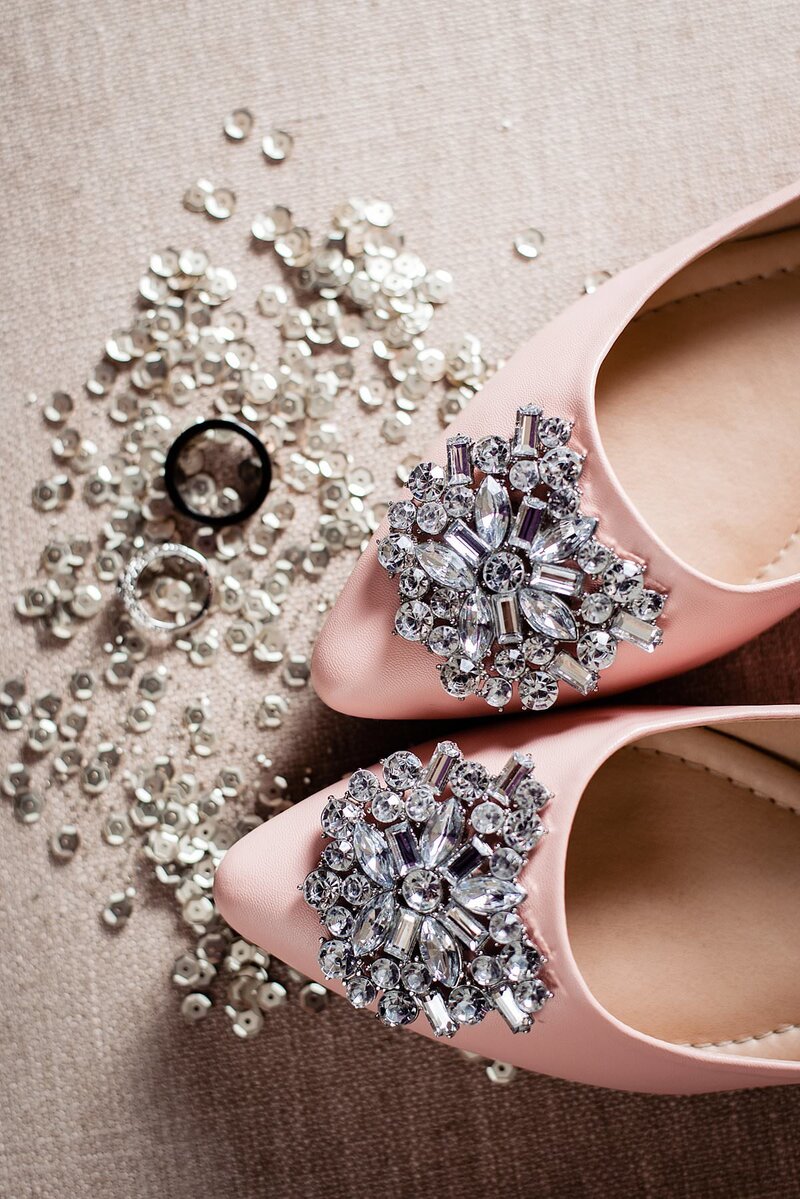 Detail photo of brides pink shoes and their wedding rings