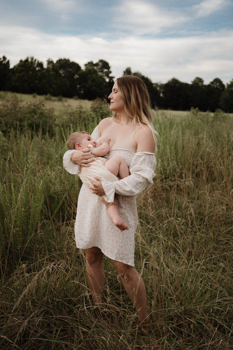 breastfeeding mother with child in a field
