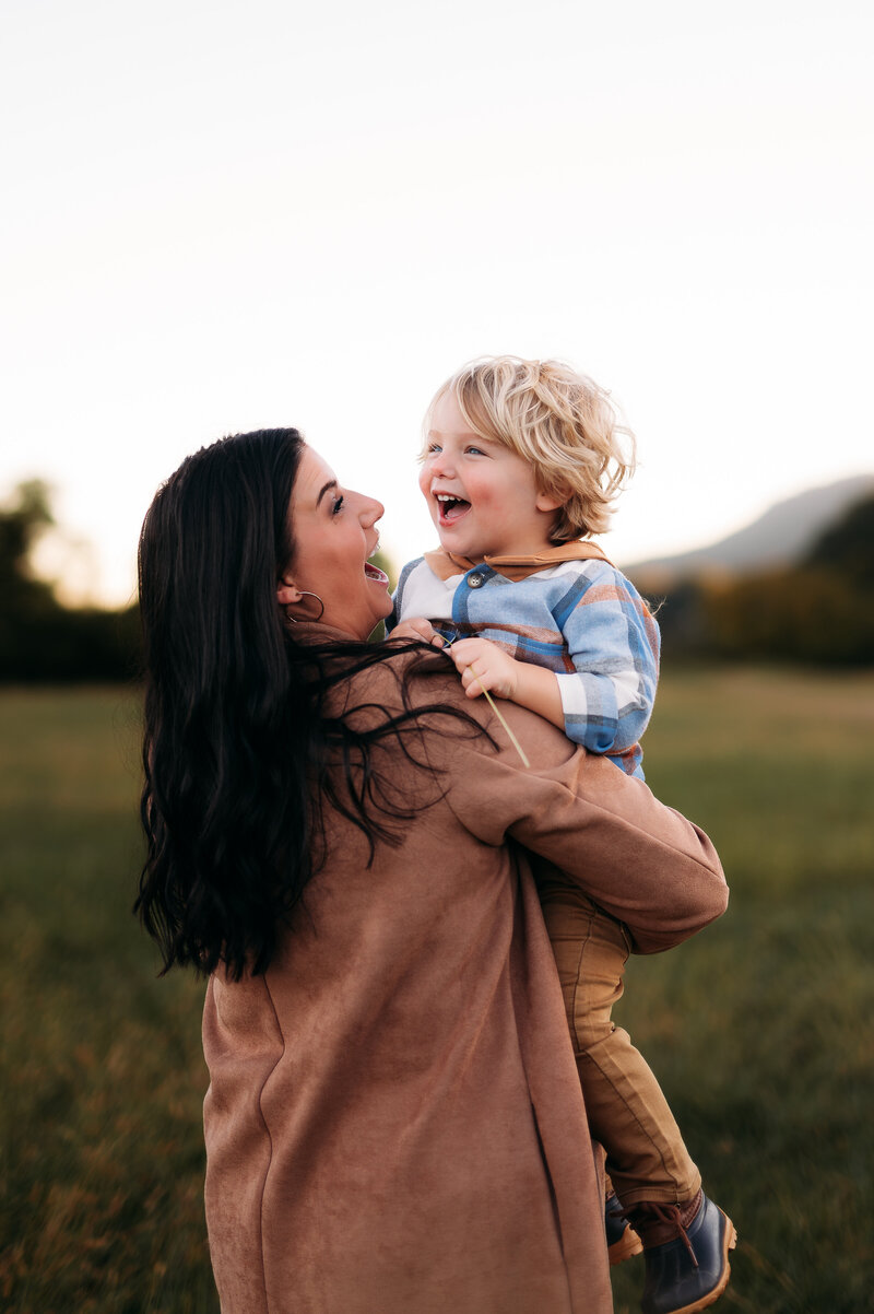candid portrait of mom and son laughing during fall session