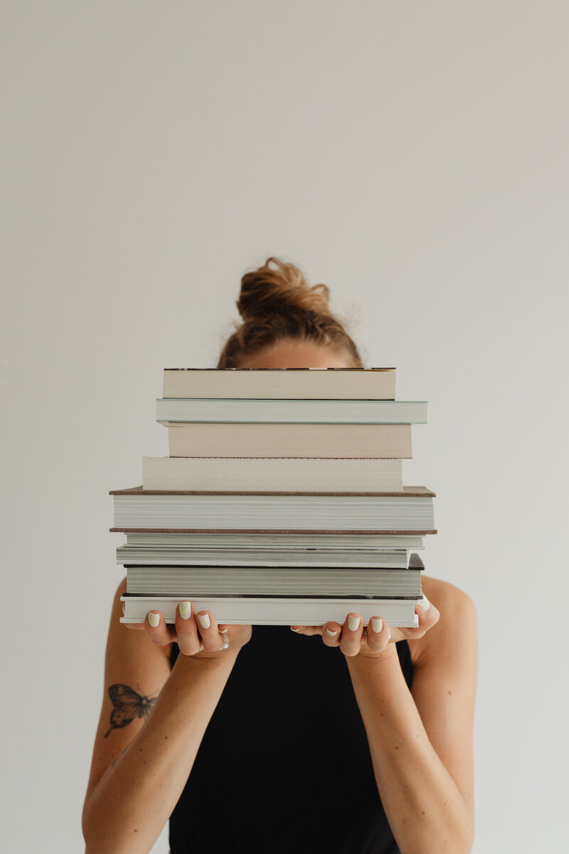 kaboompics_woman-in-light-colored-jeans-with-books-28221