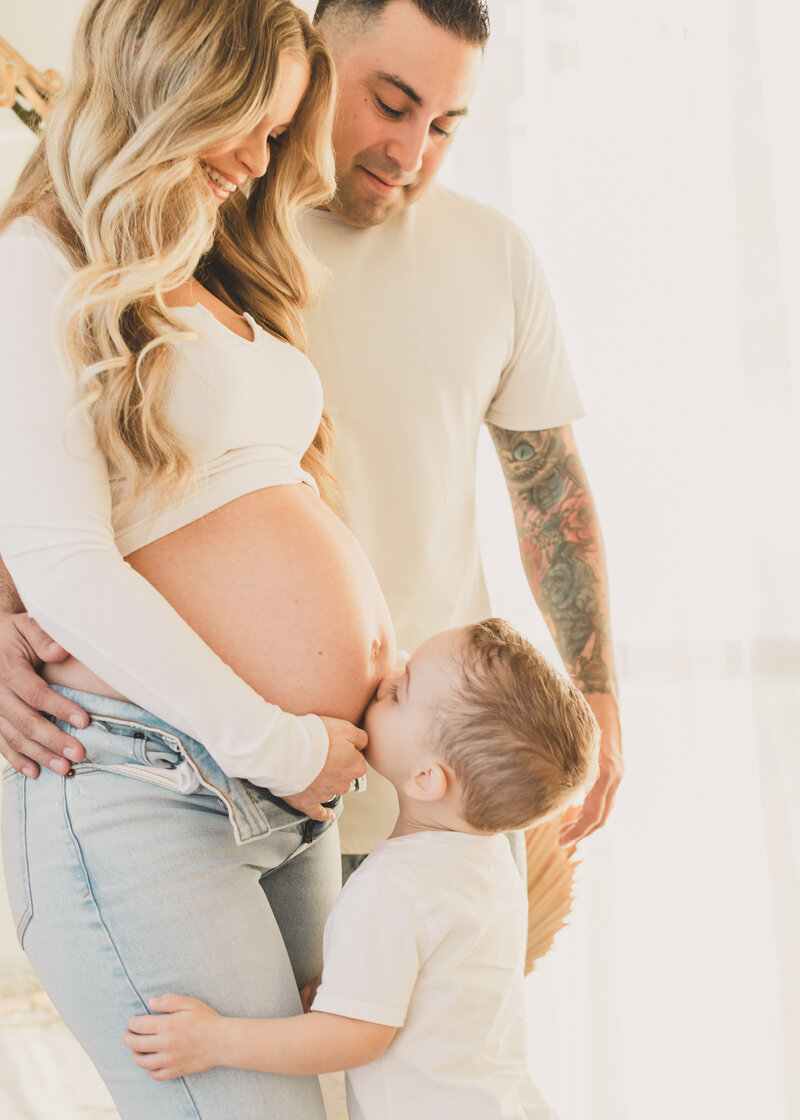 pregnant mom poses with son and husband for family maternity photos at the landing space in las vegas