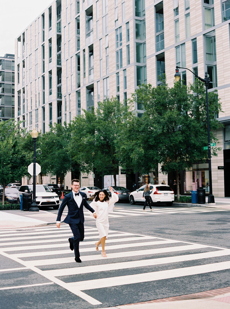 Bride and groom running across the road