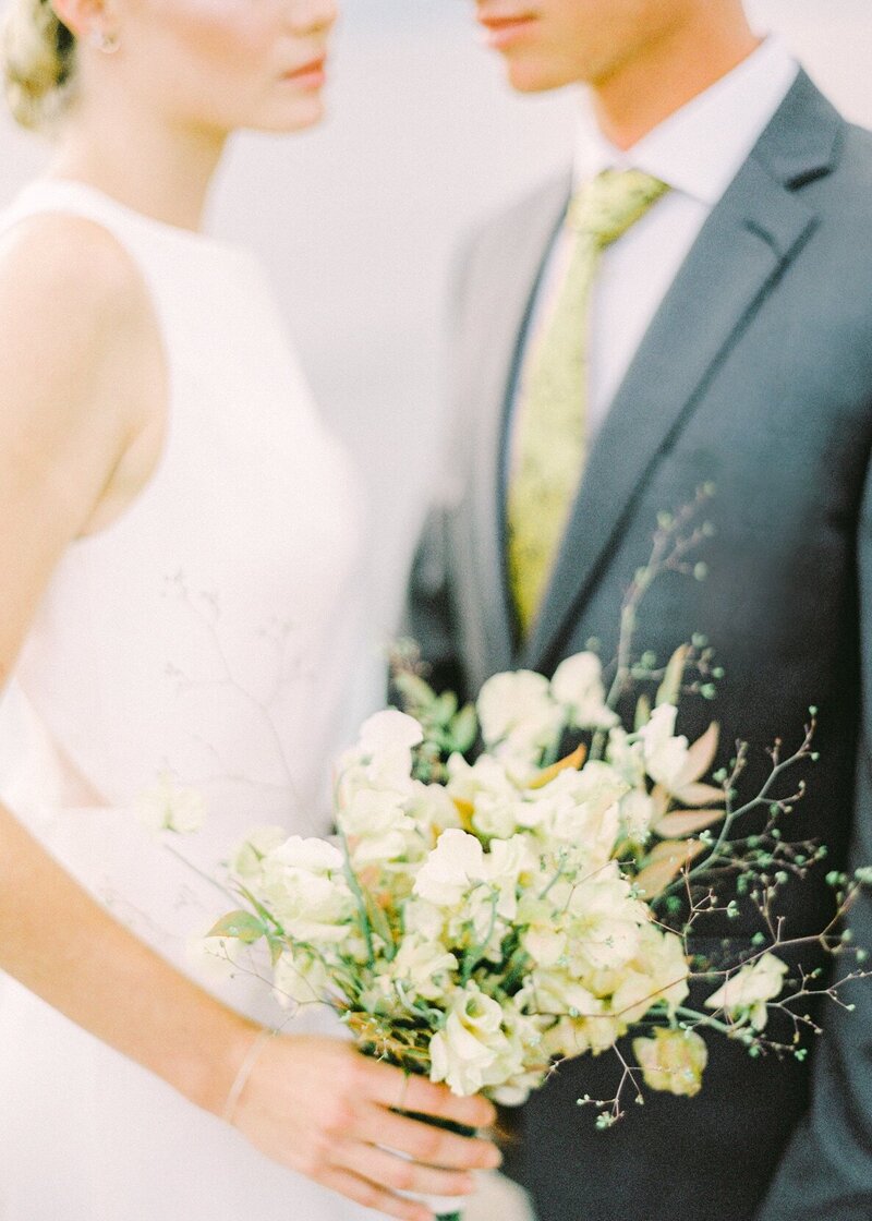 elopement wedding bride and groom with pale yellow flowers and tie