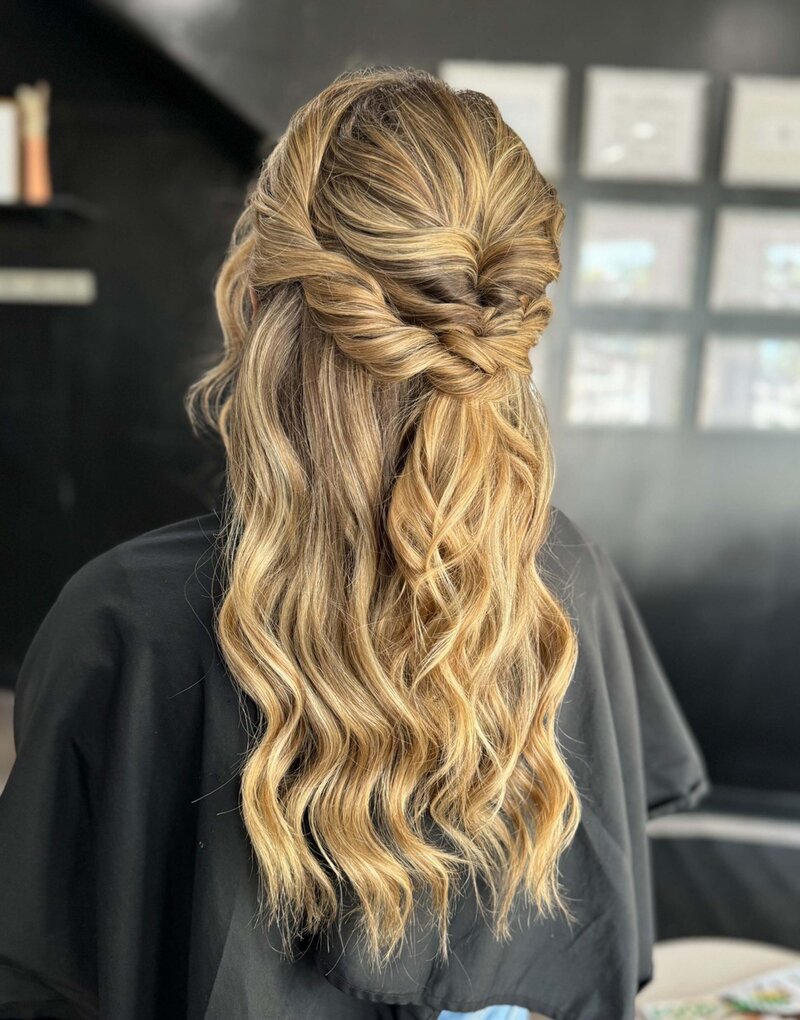 A curled bridal half up hairstyle in a salon