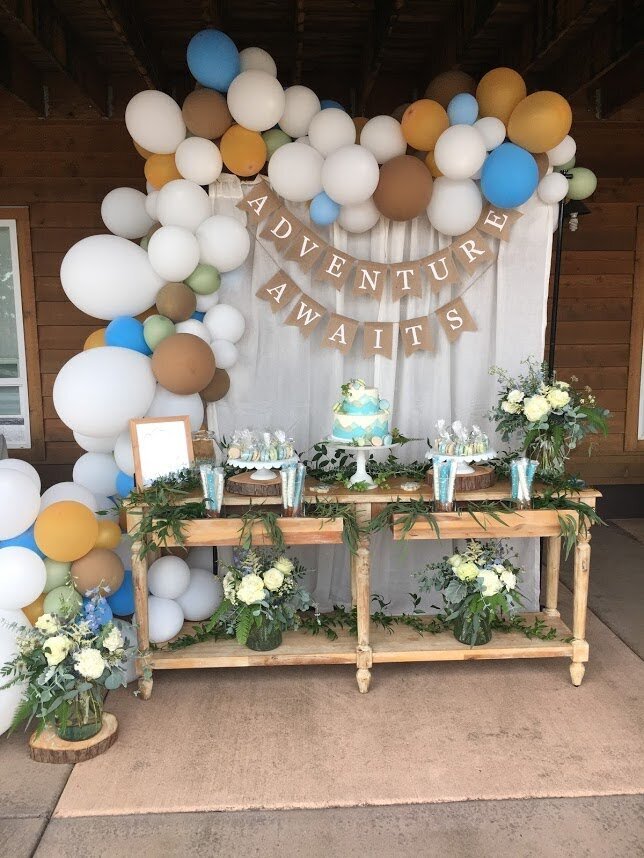 Baby shower decor with balloons, cakes and greenery and flowers showcases floral design for all occasions.
