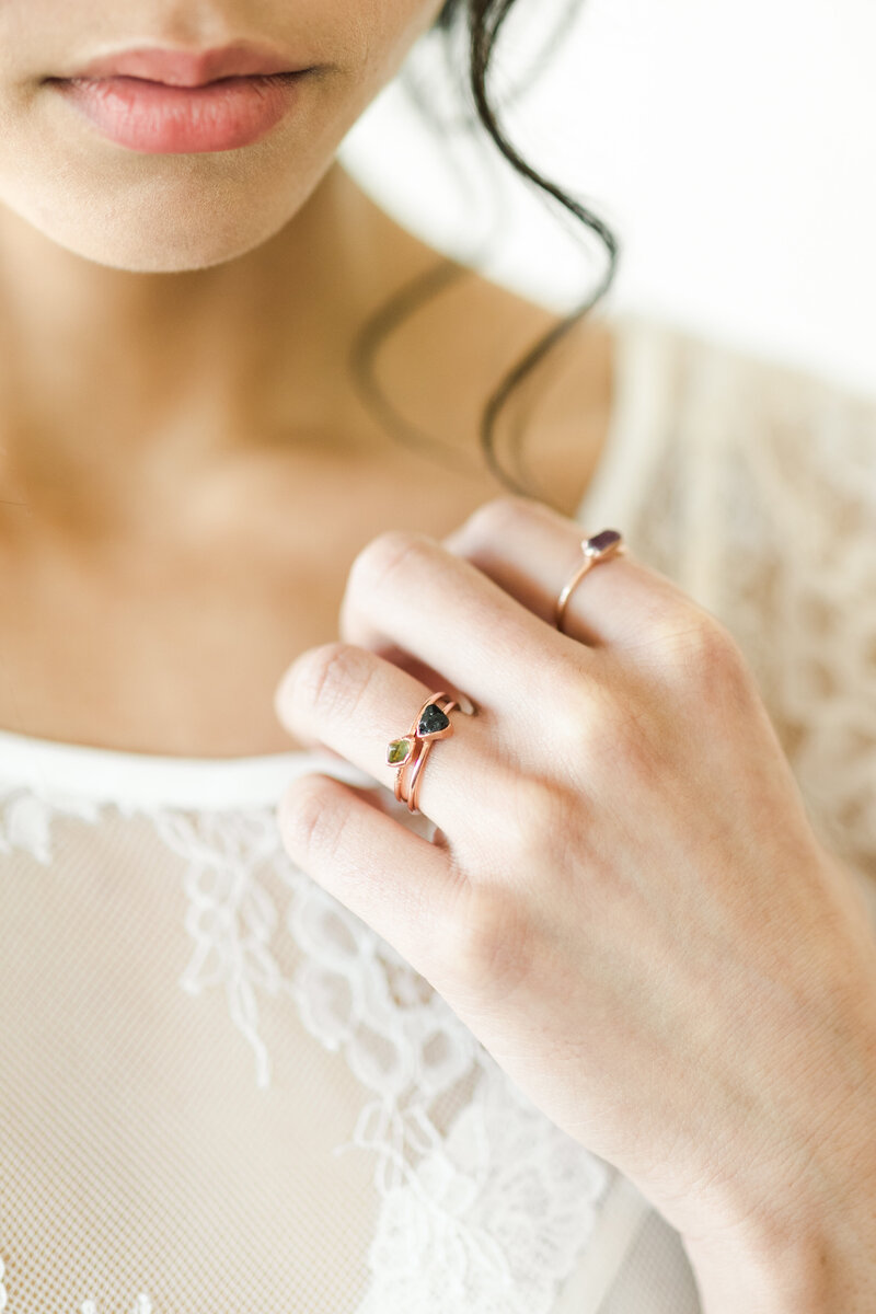 Close up of woman's hand and jewelry, wearing white lace top
