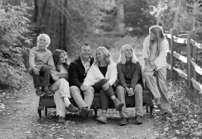Family photo of parents and four kids laughing at eachother