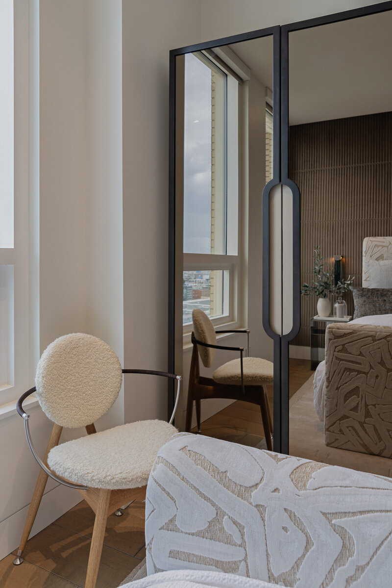 Close up shot of glass wardrobe reflection of textured seating and layered furnishings by Sister Studio.