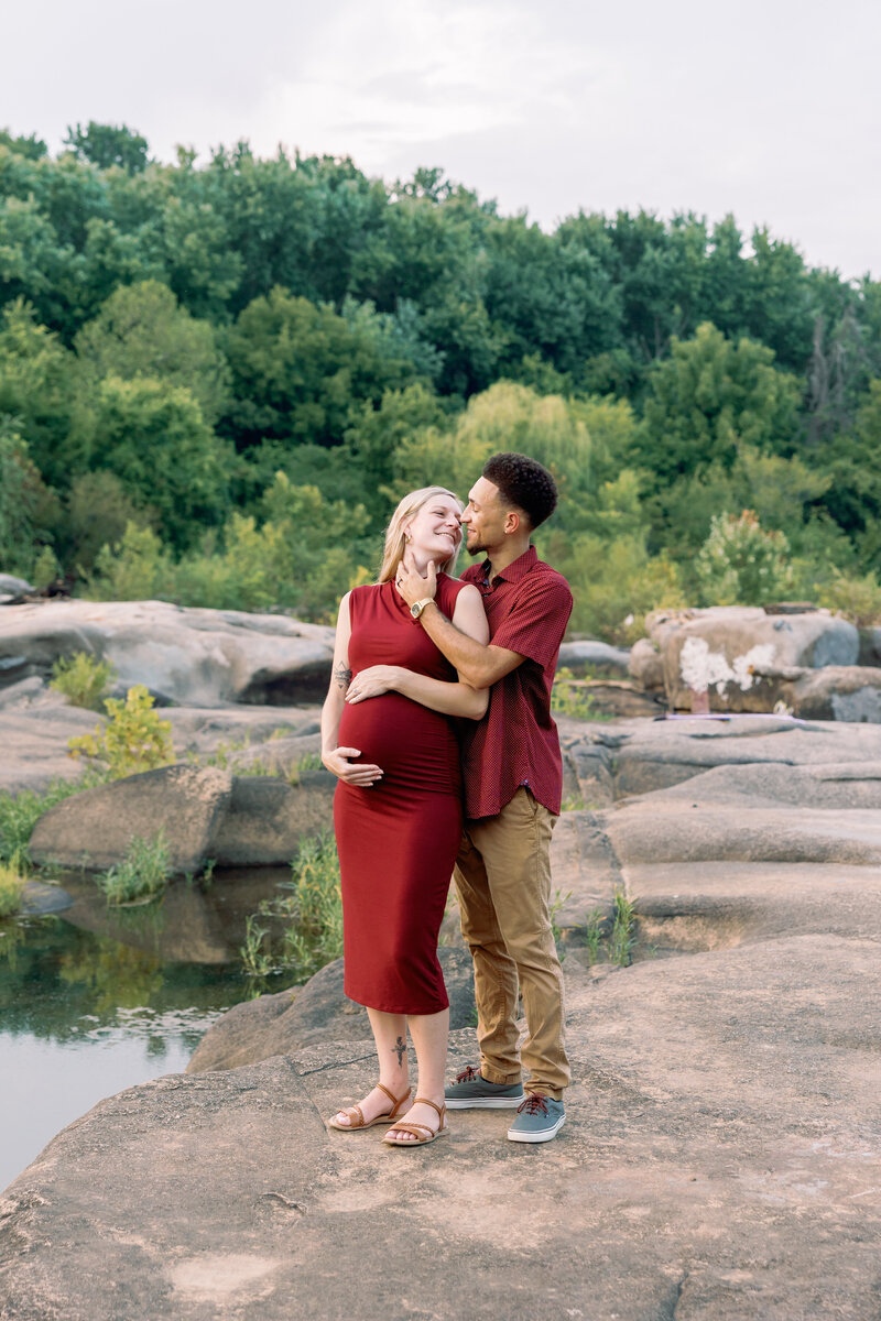Expecting couple embracing during a scenic outdoor maternity shoot in Richmond, VA
