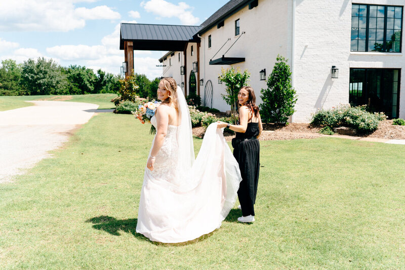 A wedding photographer assisting the bride.