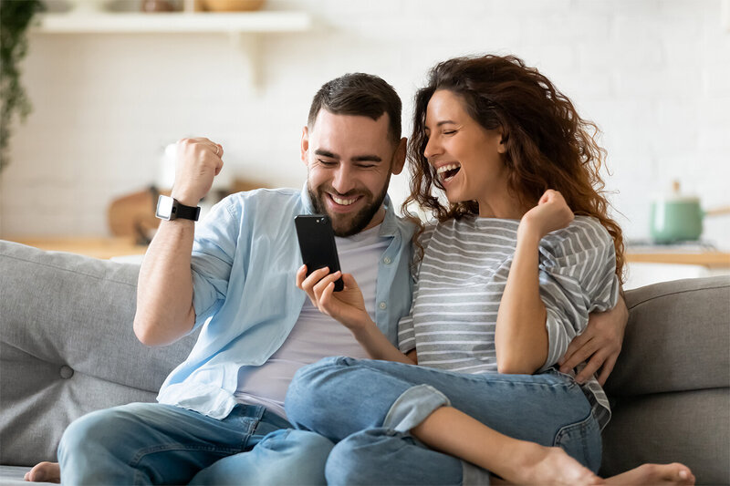 couple sitting on couch excited about good news