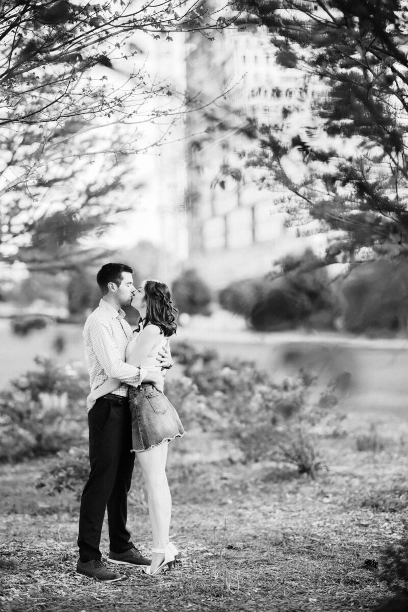 engaged couple sharing a kiss, black and white photo