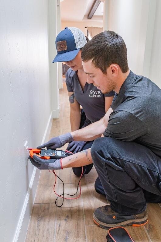 Two electricians in Albuquerque working on outlet in home