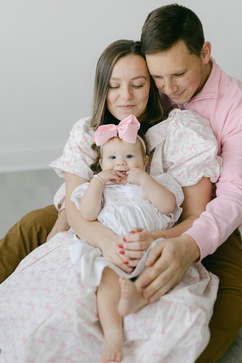 knoxville tennessee newborn photographer family snuggled up on the floor together holding each other with baby looking at camera